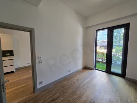 Modern bedroom area with large windows and city view in a 1+1 apartment for sale in Şişli.
