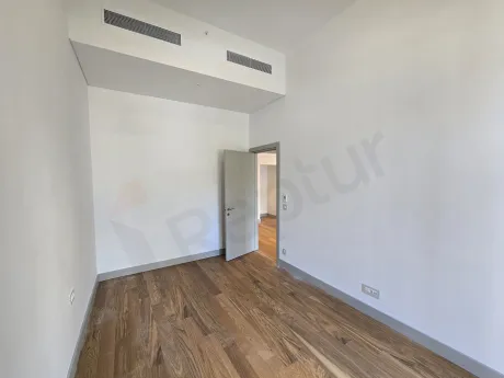 A modern designed, bright bedroom with large windows and natural sunlight.