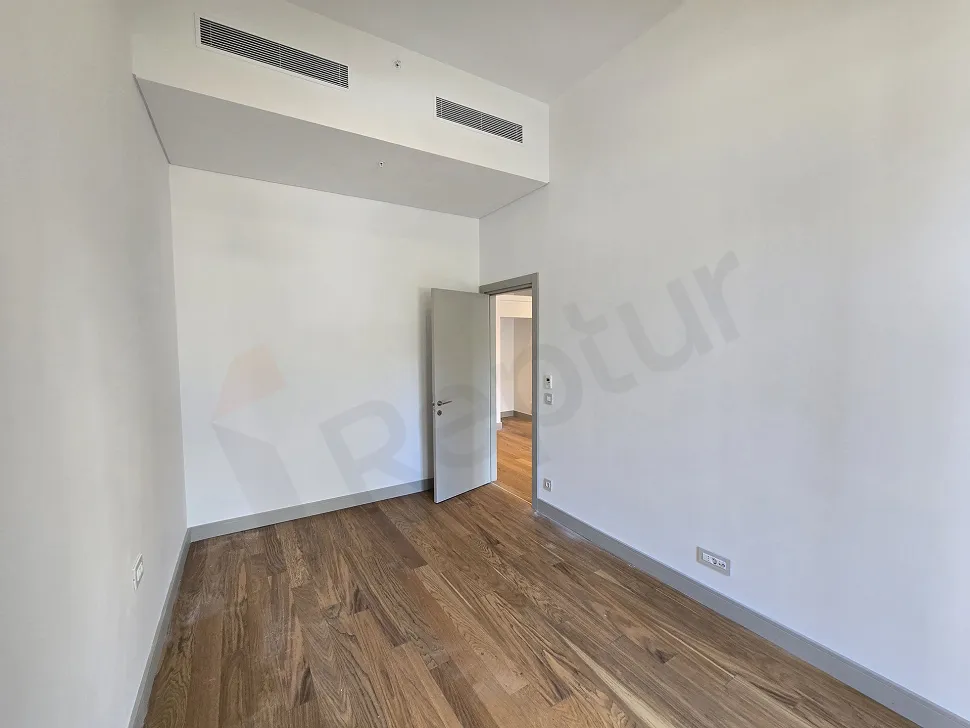 A modern designed, bright bedroom with large windows and natural sunlight.