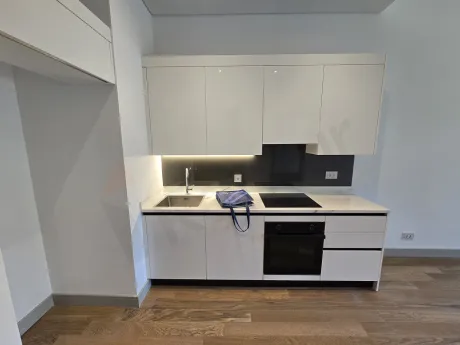 View of a spacious and bright open-plan kitchen area in a modern apartment.