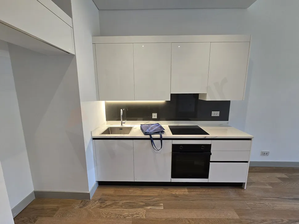 View of a spacious and bright open-plan kitchen area in a modern apartment.