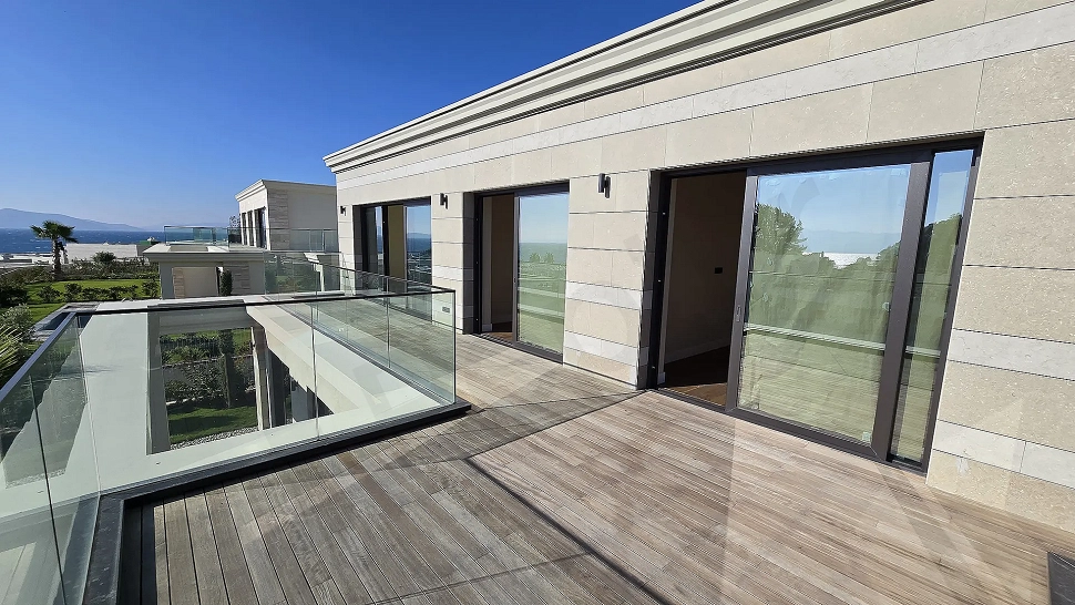 A wide and spacious terrace area with modern architecture opening to a sea view.