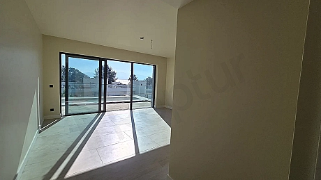 View of a bright and spacious living room with large windows in a modern building.