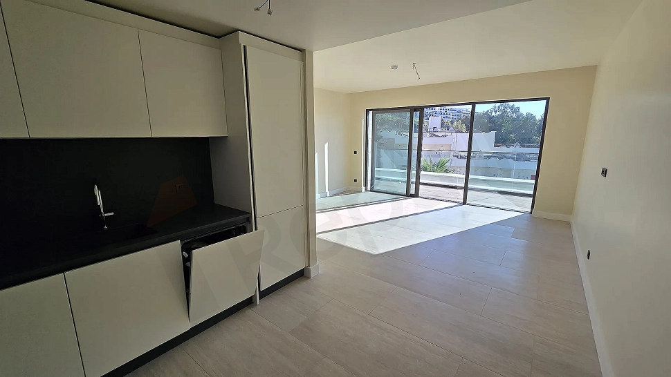 Modern and spacious open-plan kitchen area in a bright new apartment project.