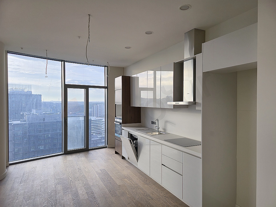 Bright kitchen with modern design, white cabinets and wooden countertop.