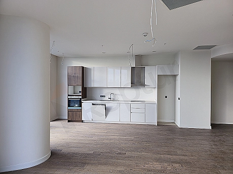 Modern designed living room interior, featuring large windows, wooden parquet flooring, and stylish furniture.
