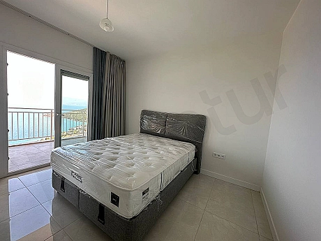 A spacious apartment balcony with sea views and modern furniture in Bodrum.