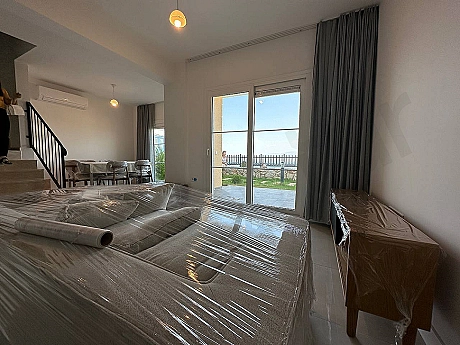 A visual of a spacious and bright living room furnished with modern furniture.