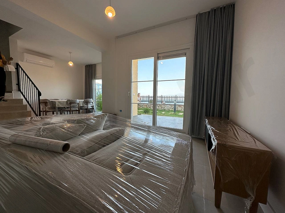 A visual of a spacious and bright living room furnished with modern furniture.