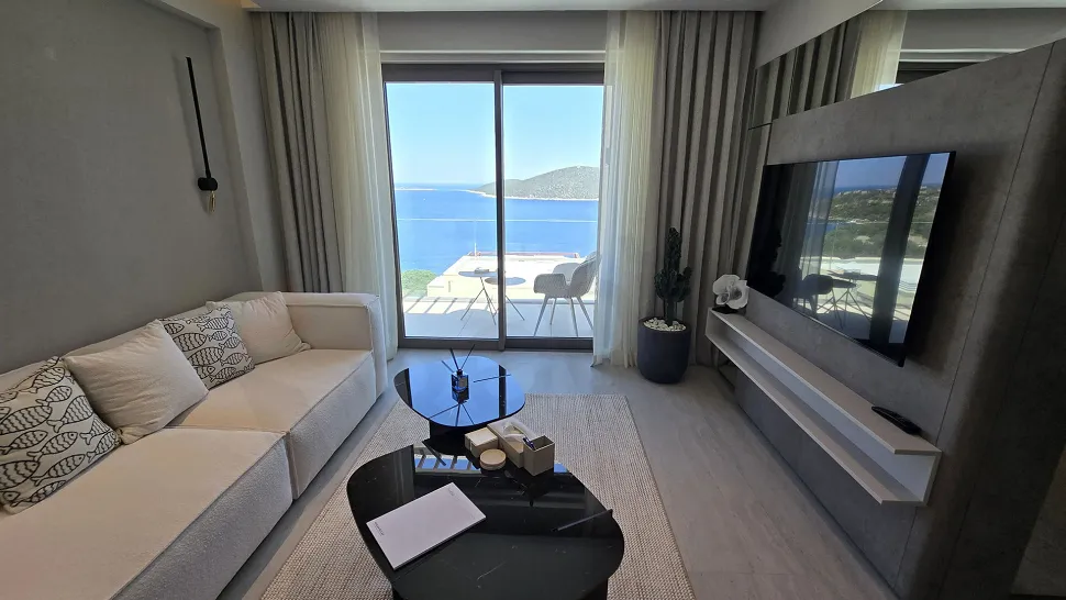 Spacious living room with modern architecture, large windows, and a sea view.