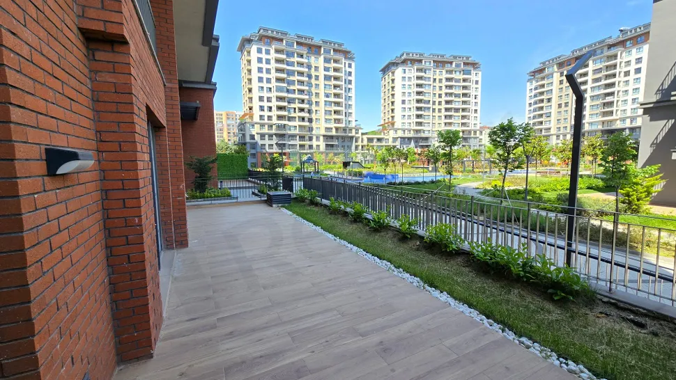 A wide and modern terrace of a duplex apartment with a city view.
