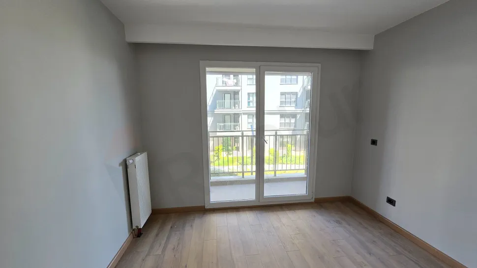 Interior view of an empty bedroom with large windows and modern design in Beylikdüzü.