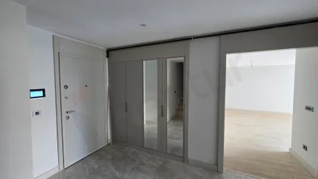 Elegant and spacious apartment entrance with a steel door in a modern building.
