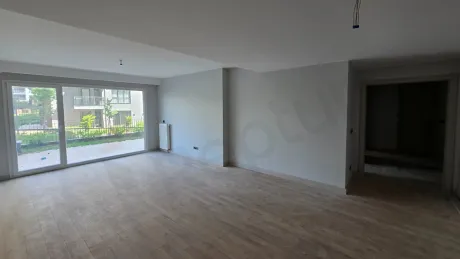 A spacious, bright empty living room area with large windows and modern architectural design.