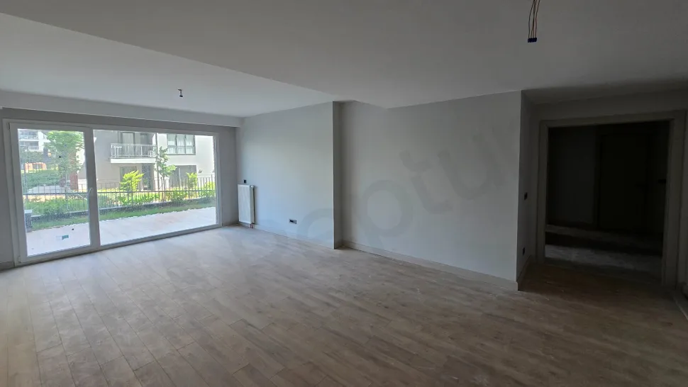 A spacious, bright empty living room area with large windows and modern architectural design.
