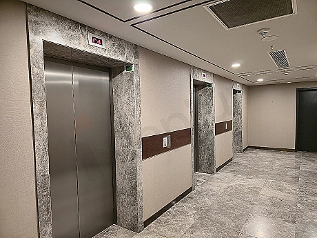 Interior of a modern elevator cabin, stainless steel details, lighting, and control panel.