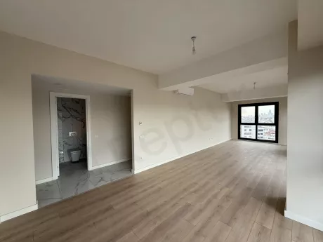 Spacious and brightly lit living room area with a modern design and large windows.