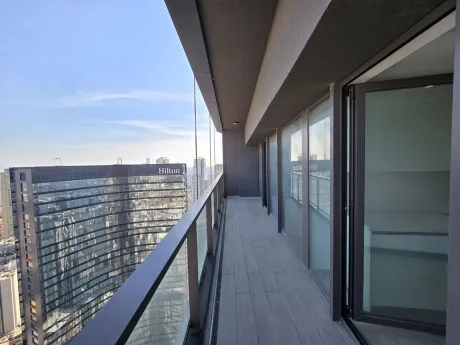 A spacious and modern apartment balcony with a city view