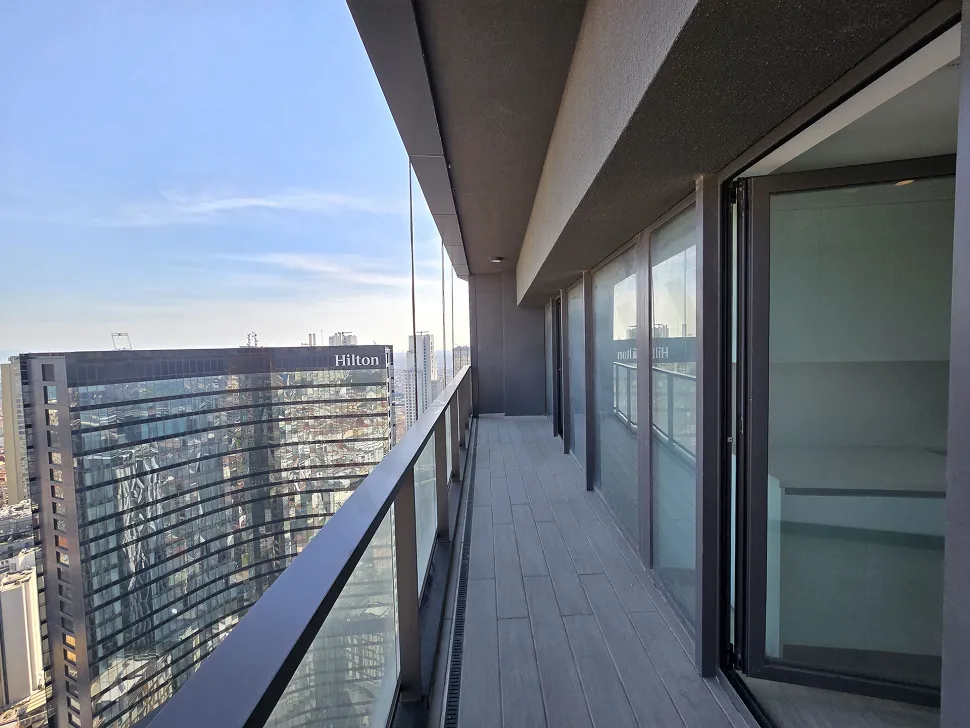 A spacious and modern apartment balcony with a city view