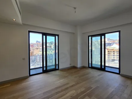 Living room interior of a spacious and modern residence apartment with large windows.