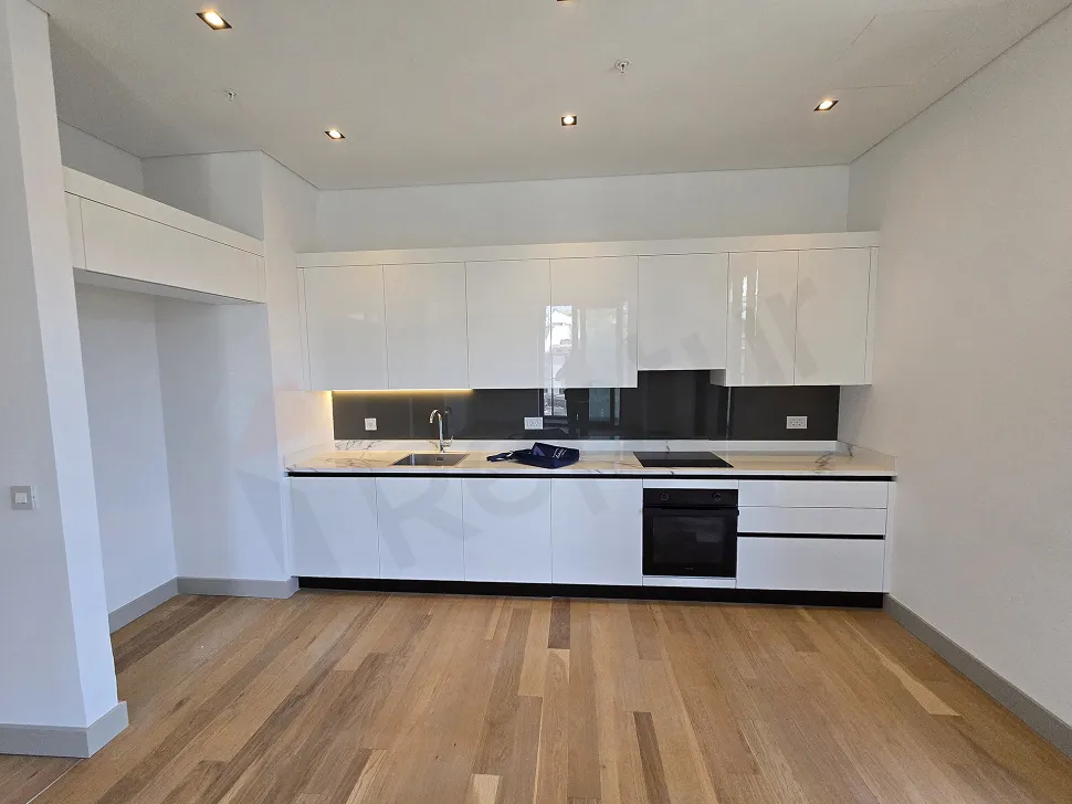 View of modern built-in kitchen cabinets and spacious kitchen countertop.