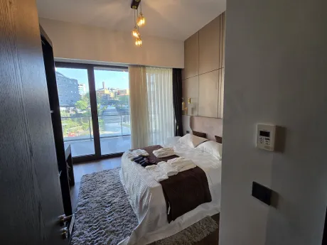 Interior view of a modern, bright bedroom with large windows in a luxury residence.