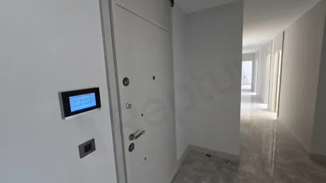 Spacious and bright entrance area of a luxury apartment in a modern building.