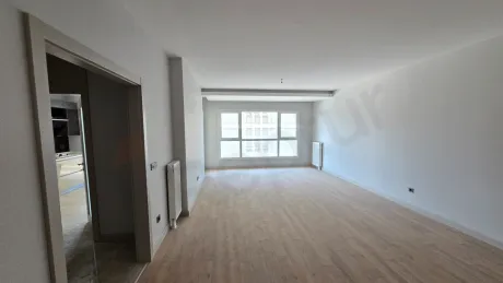 Spacious and bright living room area of a modern 4+1 apartment with large windows.