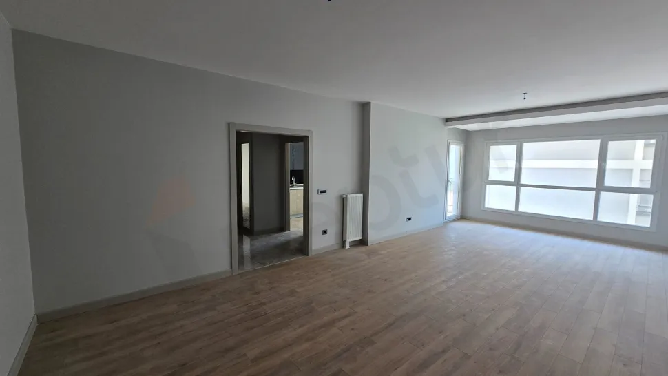 Spacious and bright modern living room area with large windows.