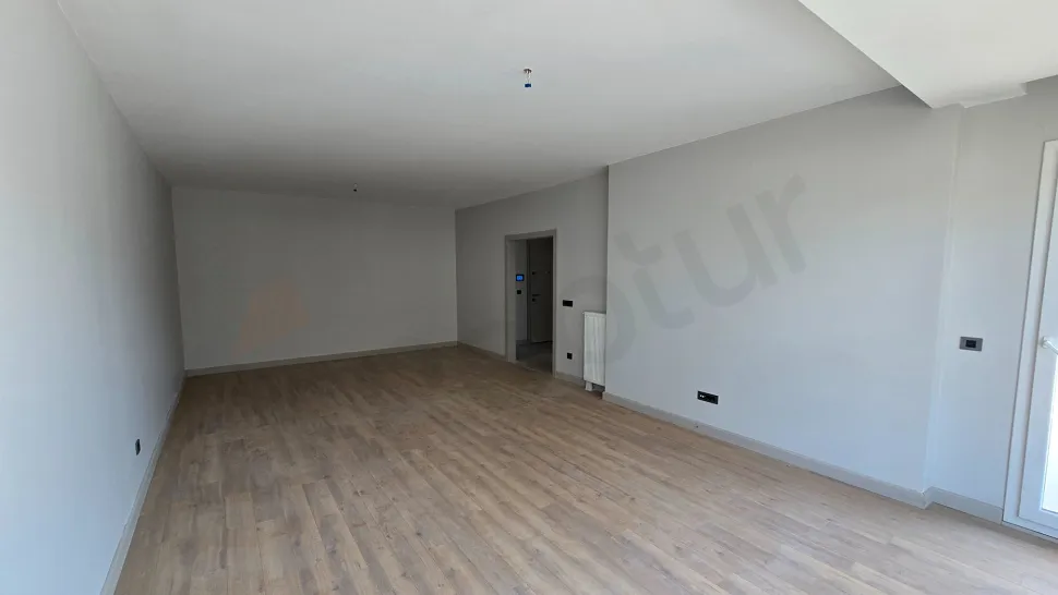 A spacious and bright living room image with large windows and modern interior design.
