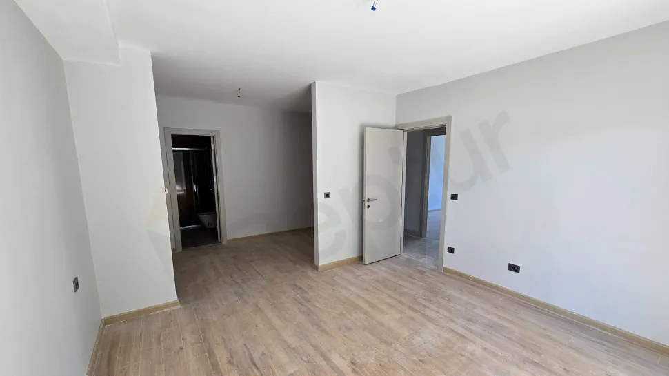 A view of a modern and spacious bedroom with large windows and a bright design.