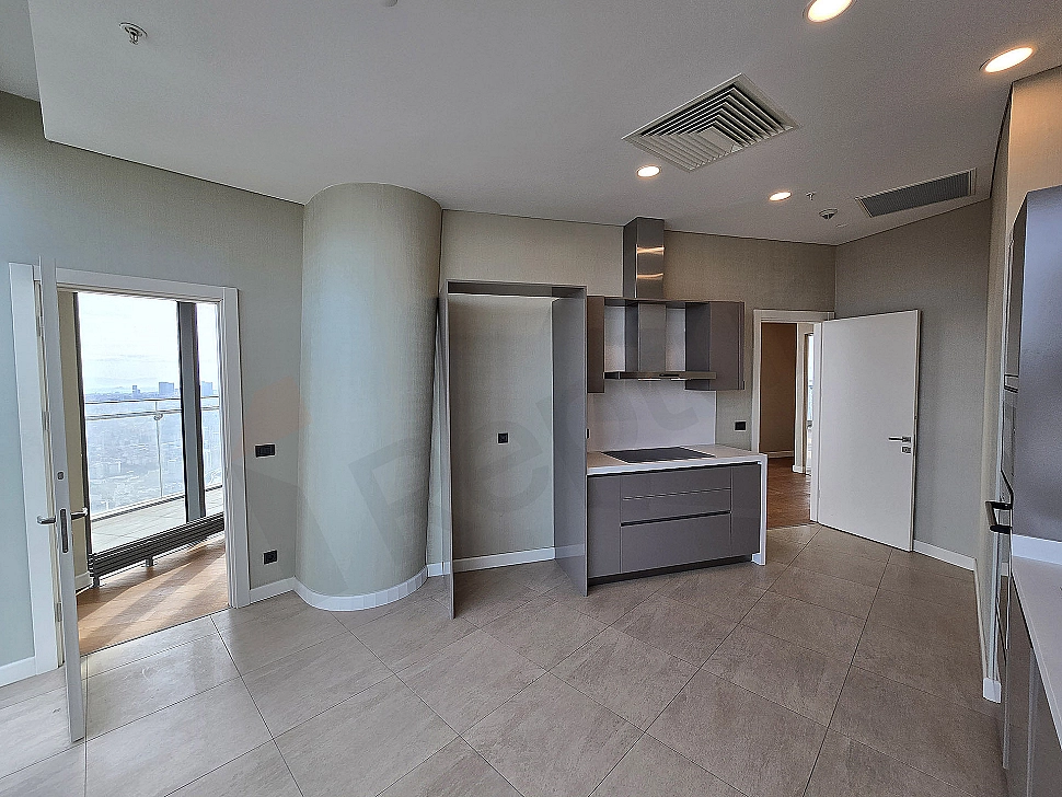 Modern designed, spacious and bright kitchen. White cabinets, wooden countertop, and built-in appliances.