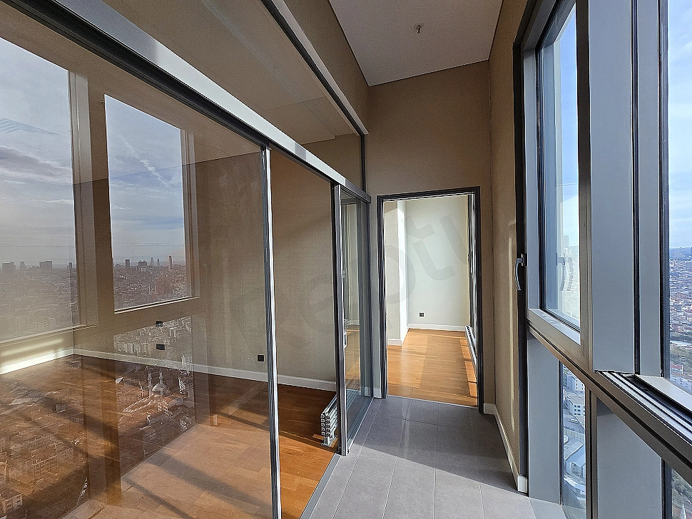 Image of a luxurious apartment with a spacious balcony featuring a seating area and city view.