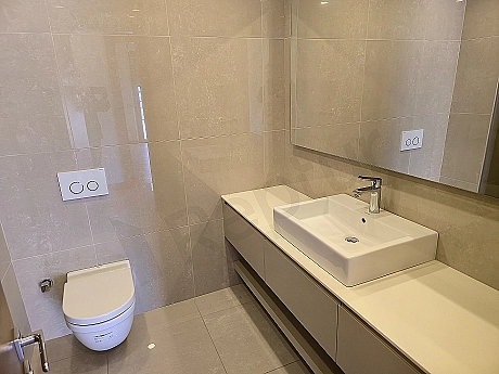 Interior of a modern designed, spacious and luxurious bathroom. Light color tones, natural stone details, and stylish fixtures are remarkable.