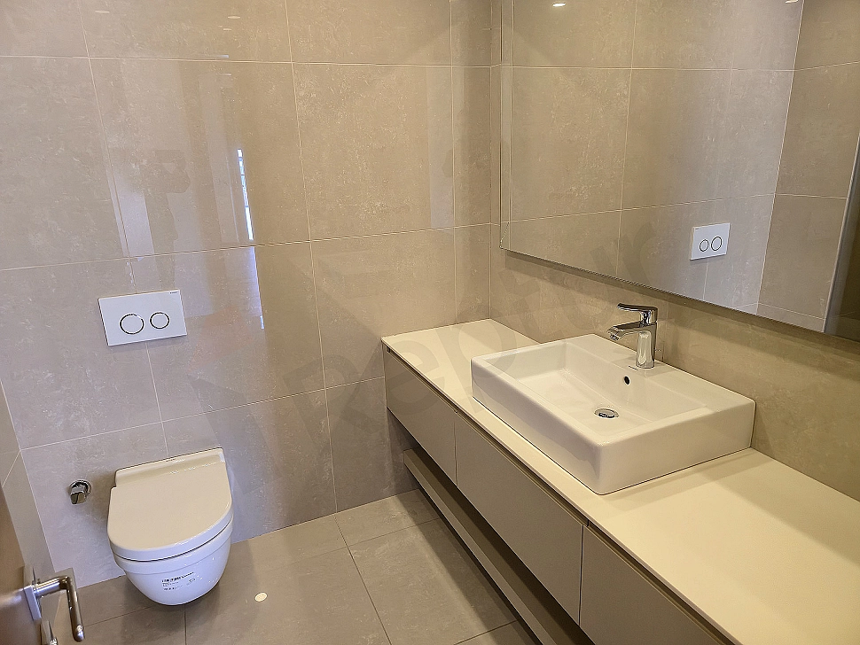 Interior of a modern designed, spacious and luxurious bathroom. Light color tones, natural stone details, and stylish fixtures are remarkable.