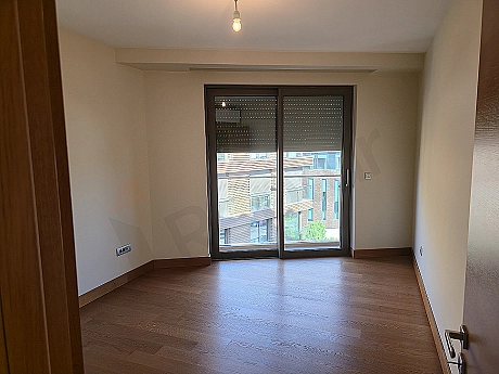 Image of a modern designed, bright and spacious bedroom. Features a large bed, stylish bedside tables, lamps, and large windows.