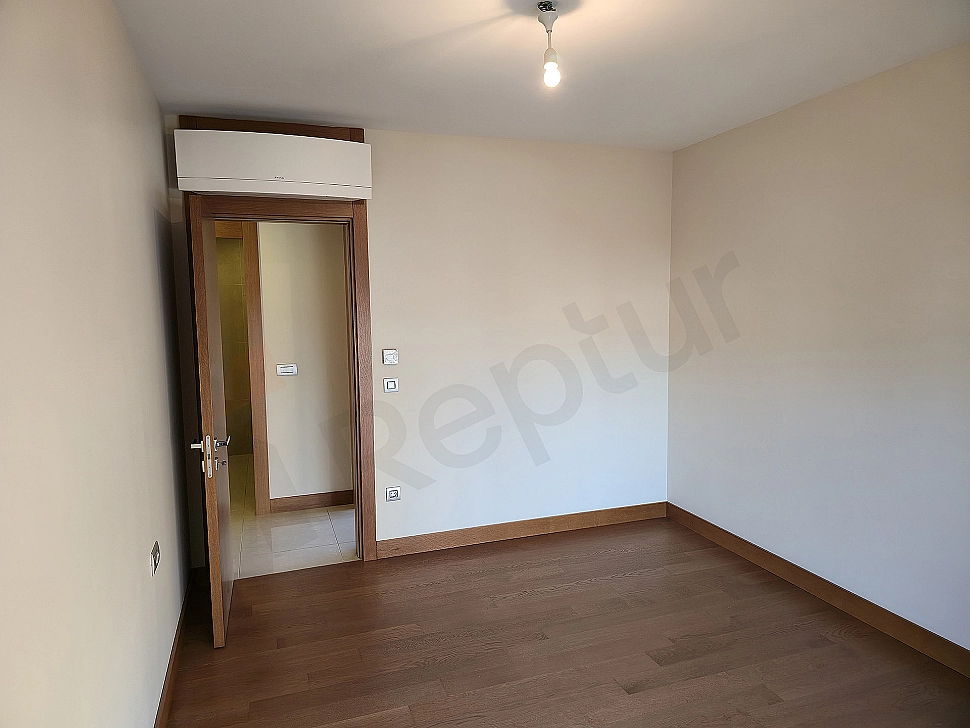 Modern bedroom interior, spacious double bed, stylish bedside tables, and decorative lighting elements.