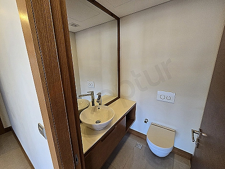 Interior of a modern designed, spacious and bright duplex apartment bathroom. Featuring a stylish sink, large mirror and shower cabin.