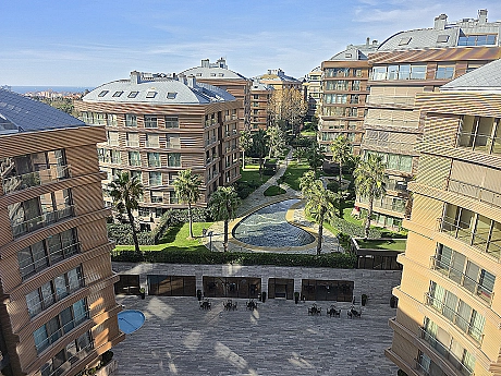 View of a spacious and well-maintained garden. Surrounded by green lawns, various plants, and trees, a peaceful living space.