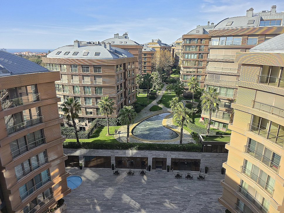 View of a spacious and well-maintained garden. Surrounded by green lawns, various plants, and trees, a peaceful living space.