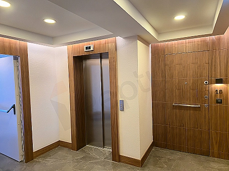 Interior view of a modern elevator cabin with stainless steel details and lighting