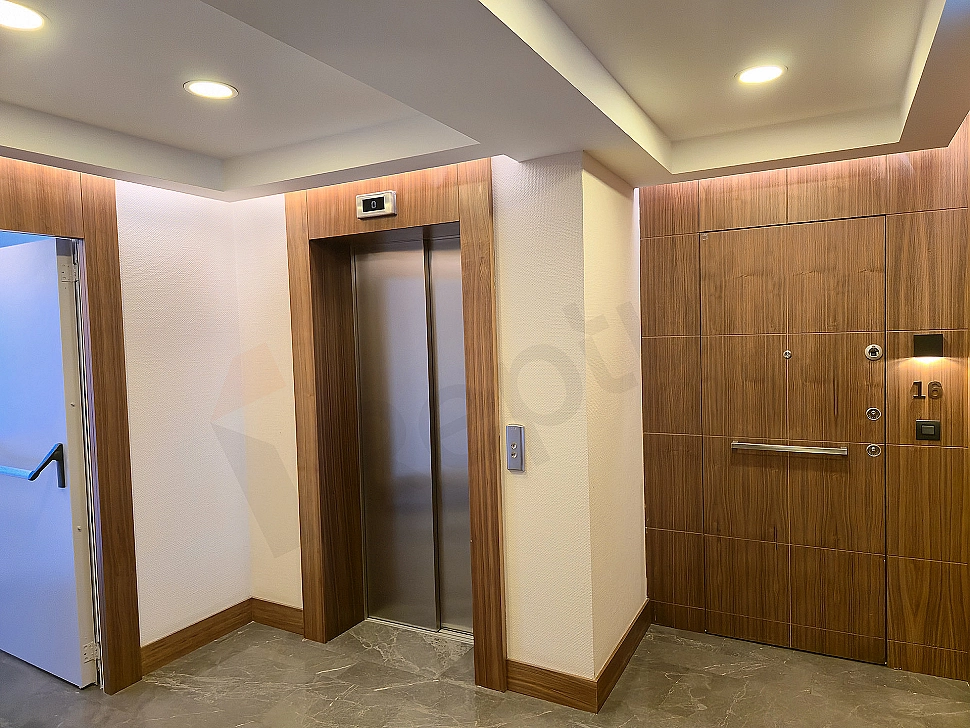 Interior view of a modern elevator cabin with stainless steel details and lighting