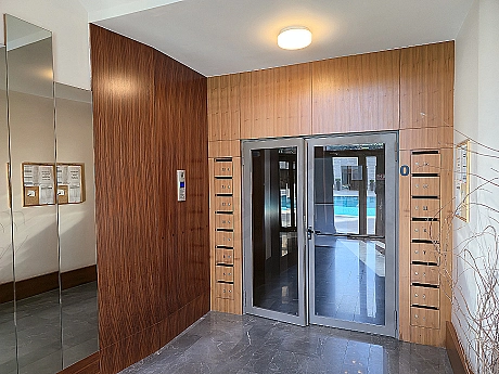 Modern building entrance facade, glass and metal details, landscape arrangement