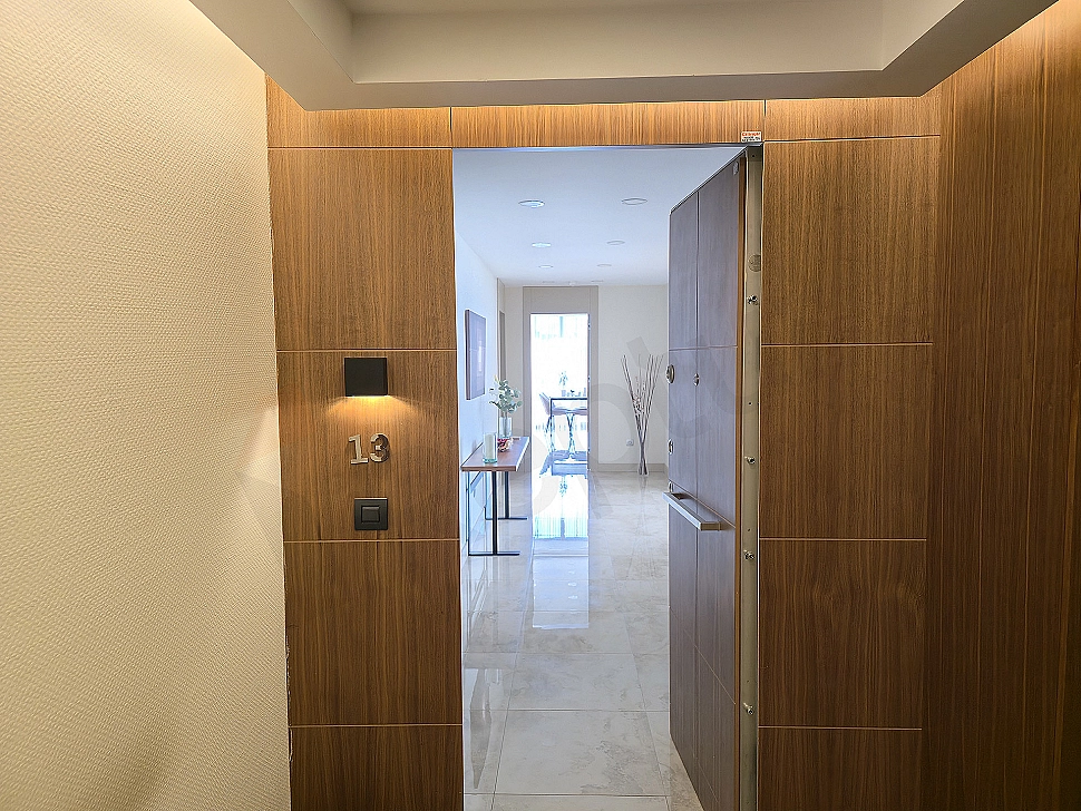 Entrance door of a 4+1 apartment for sale in Üsküdar. Wooden cladding, modern design, lighting details.