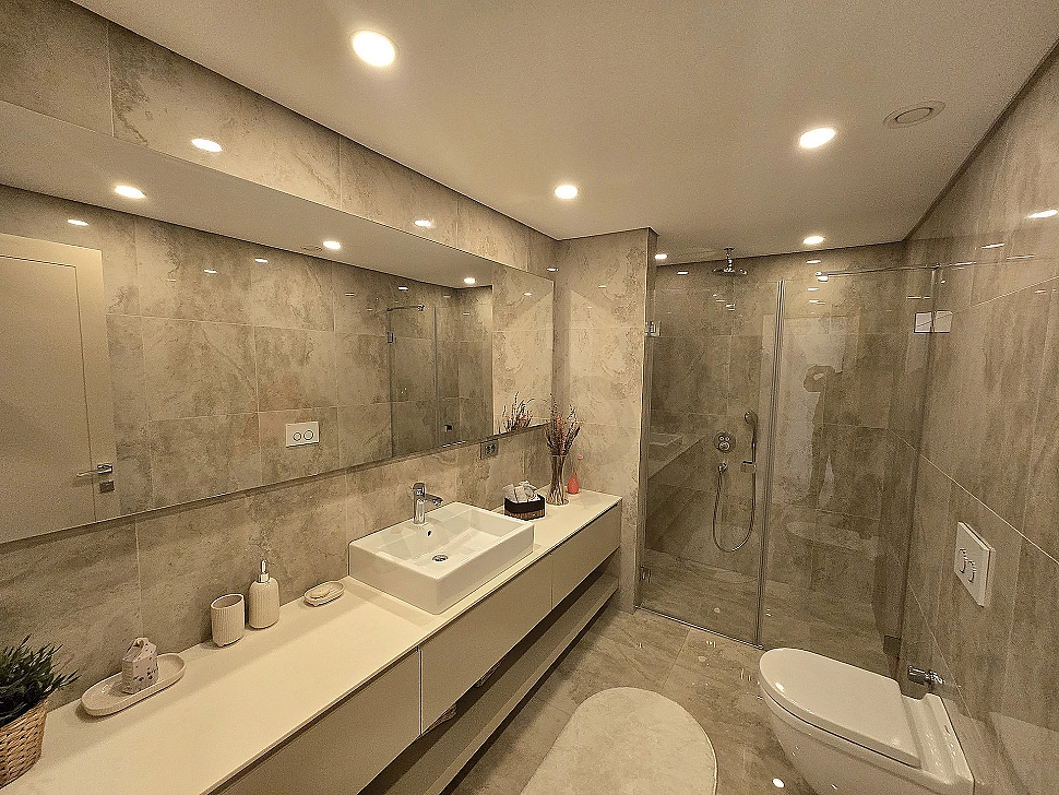 Modern designed, spacious and bright bathroom. Luxurious bathroom featuring white ceramics, stylish fixtures, and a large window.