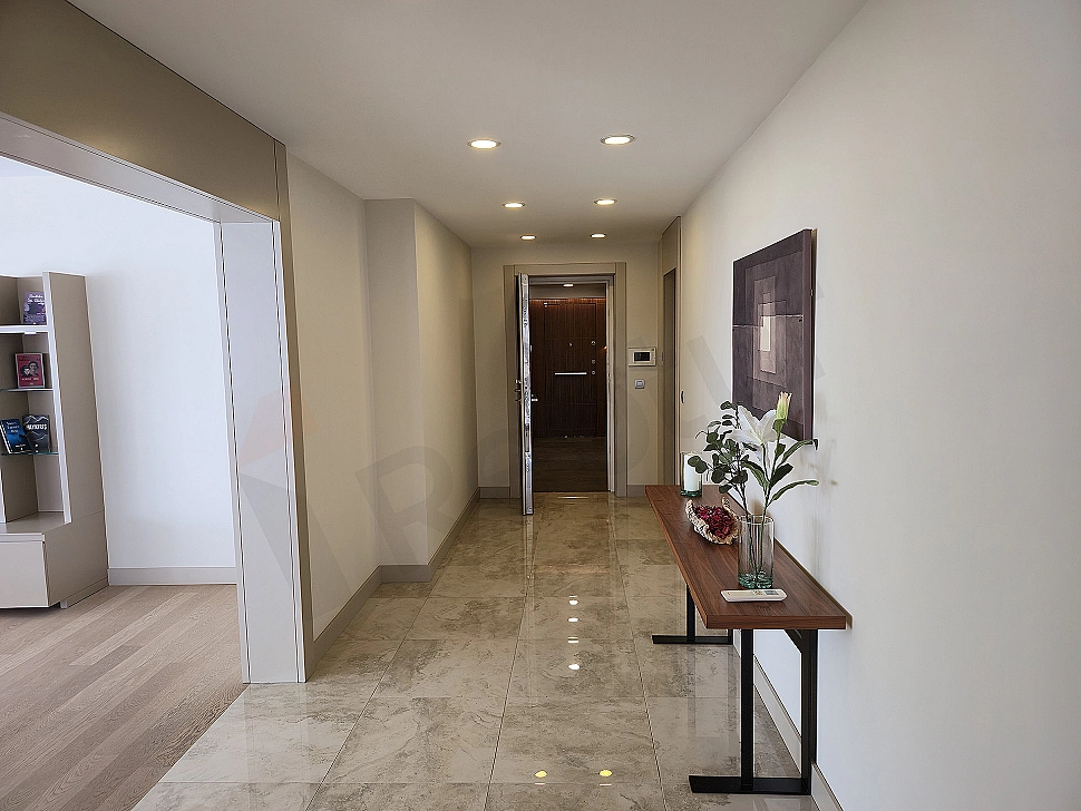 Modern designed, spacious and bright apartment hallway. Wooden floor, white walls and stylish lighting elements.