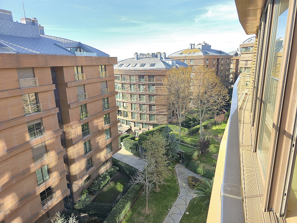 Image of a spacious and well-maintained garden. Features green lawns, flowers, trees and a peaceful outdoor seating area.