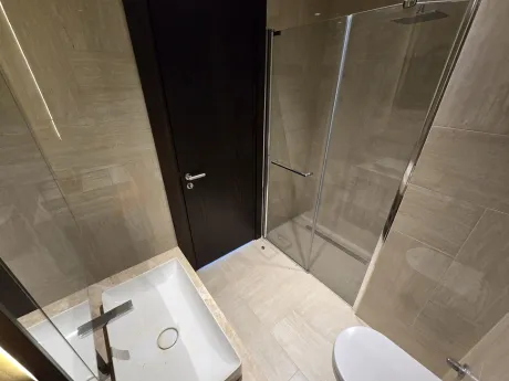 Modern and stylish bathroom with a large mirror and high-quality ceramic tiles.