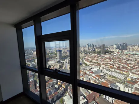 Bright bedroom with modern design, large windows, and a panoramic city view.