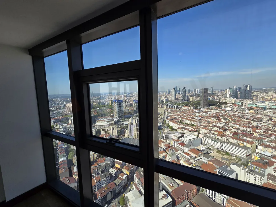 Bright bedroom with modern design, large windows, and a panoramic city view.